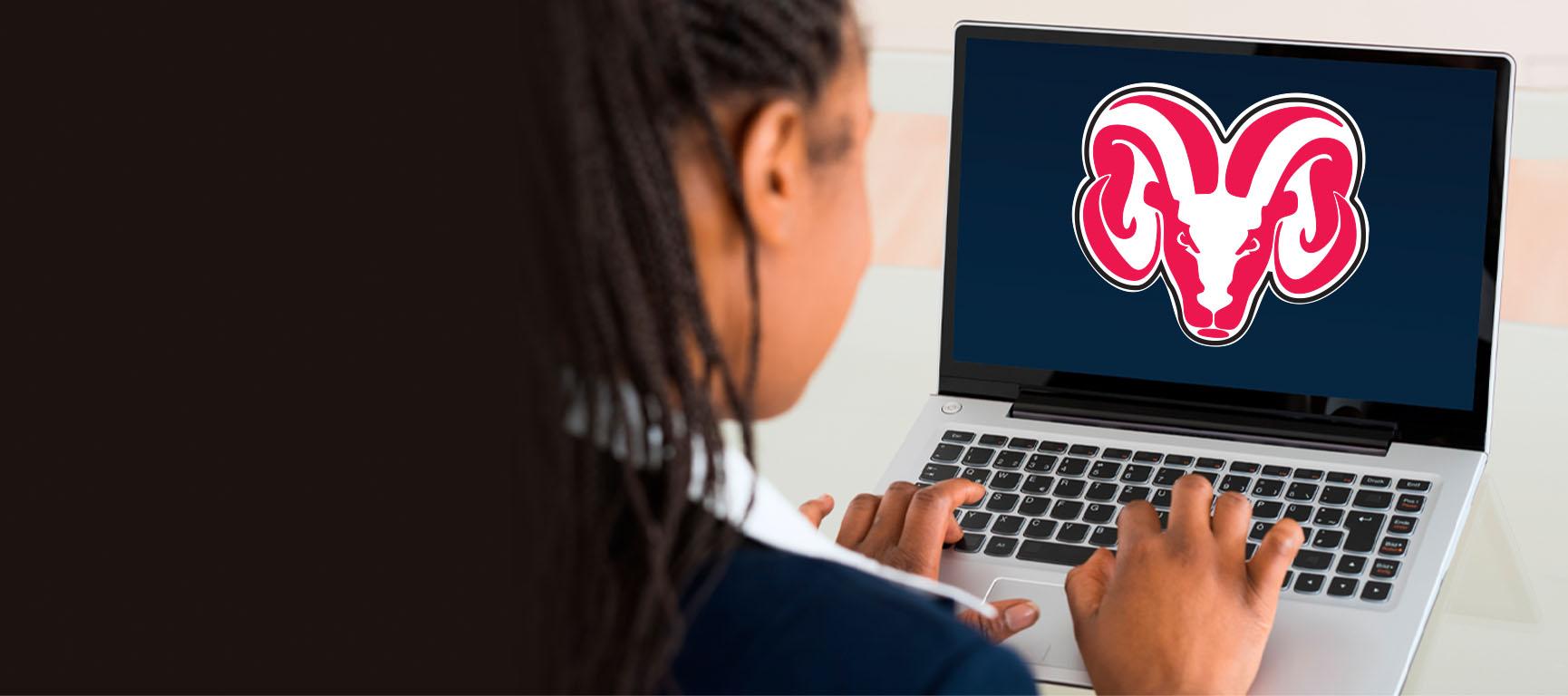 student typing on laptop