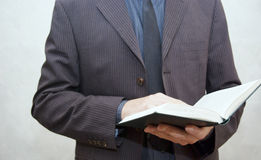 man in suit holding open book