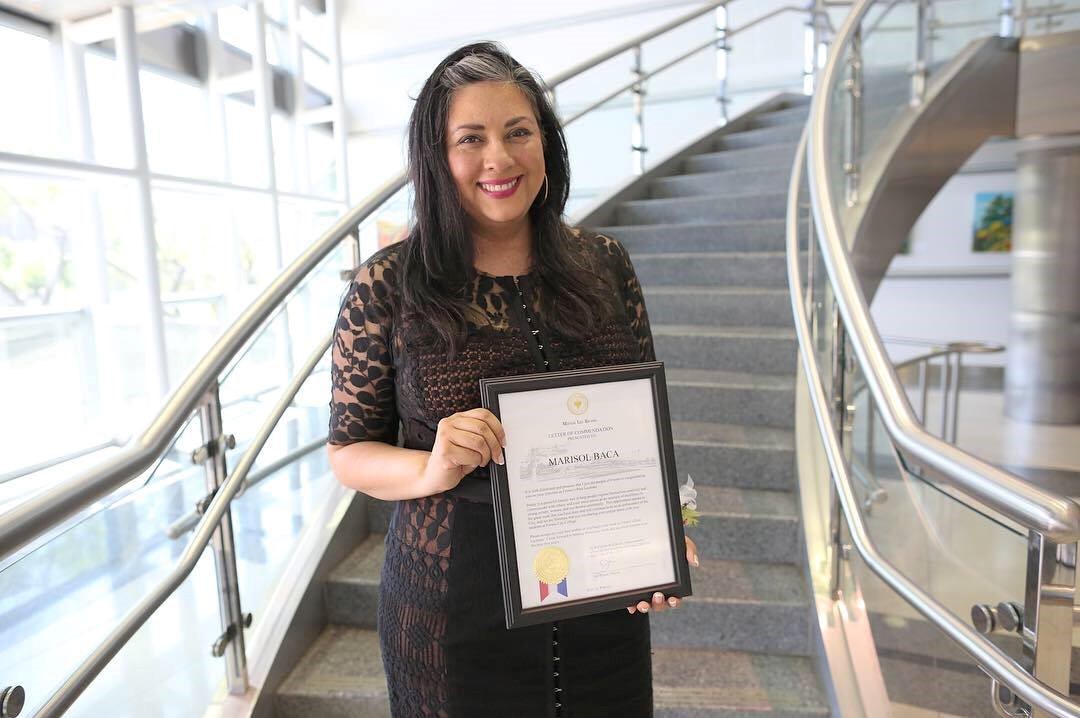 Marisol Baca holding award