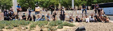 Students sitting on College Wall