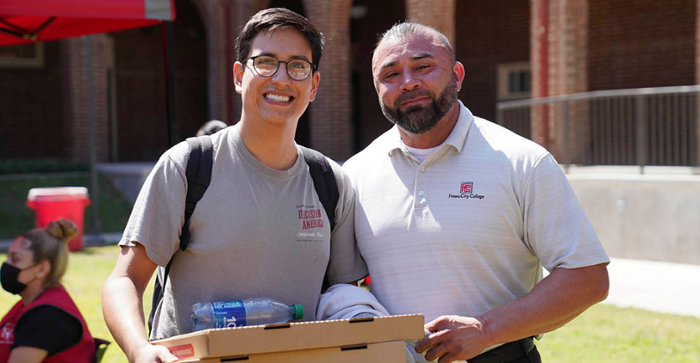 Student standing with Dr. Robert Pimentel