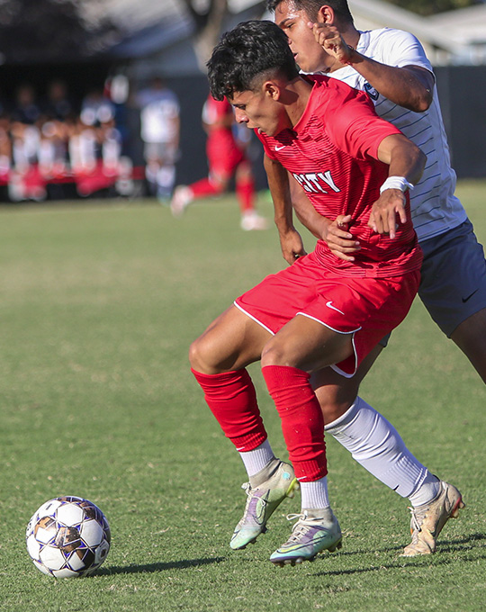 men fighting for soccer ball