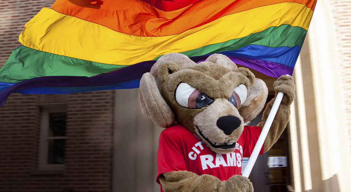 Sam the Ram holding pride rainbow flag