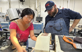 student and instructor working together using machinery