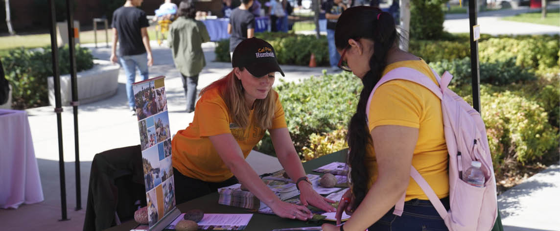 counselor helping student at table ouside