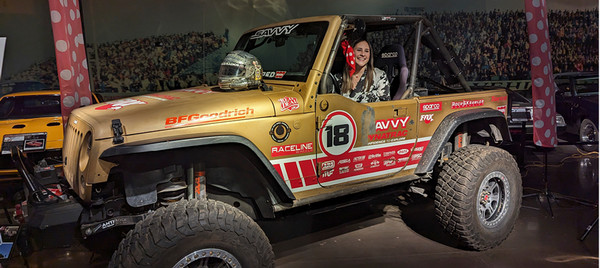 Girl driving gold jeep with red stickers