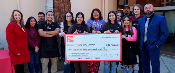 Ram Pantry staff & students holding up giant check