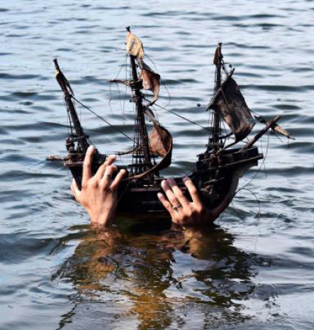 Man hiding behind toy boat