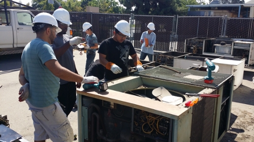      Student connects a refrigerant recovery unit 