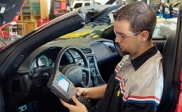 man in car holding testing tool for auto repair