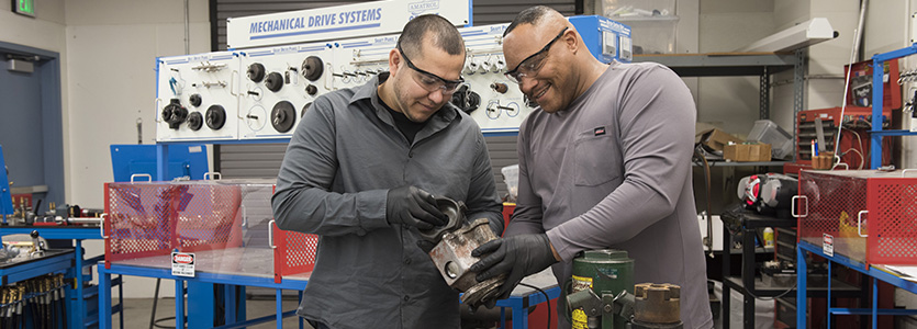 two men working with a part