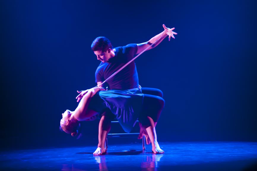 duet in soft blue light, making a pose          dancers on stage in blue light in a lunge 