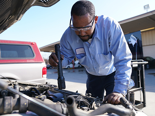 man fixing car engine