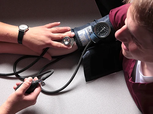 Student checking another's blood pressure