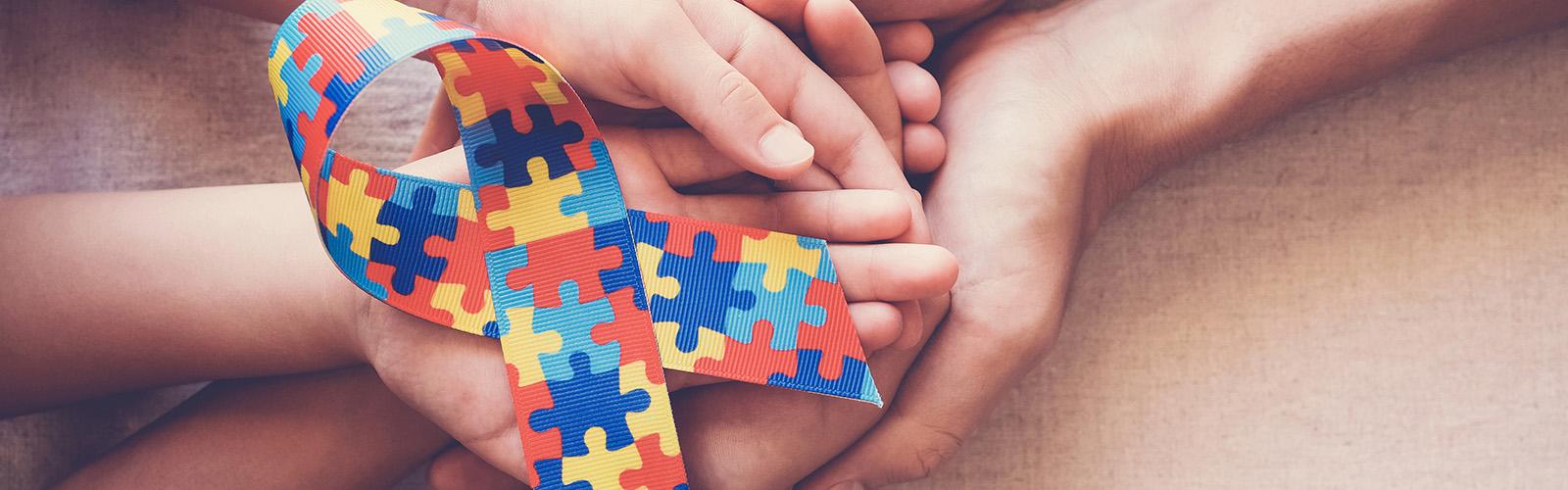 autism puzzle piece ribbon in someone's hands
