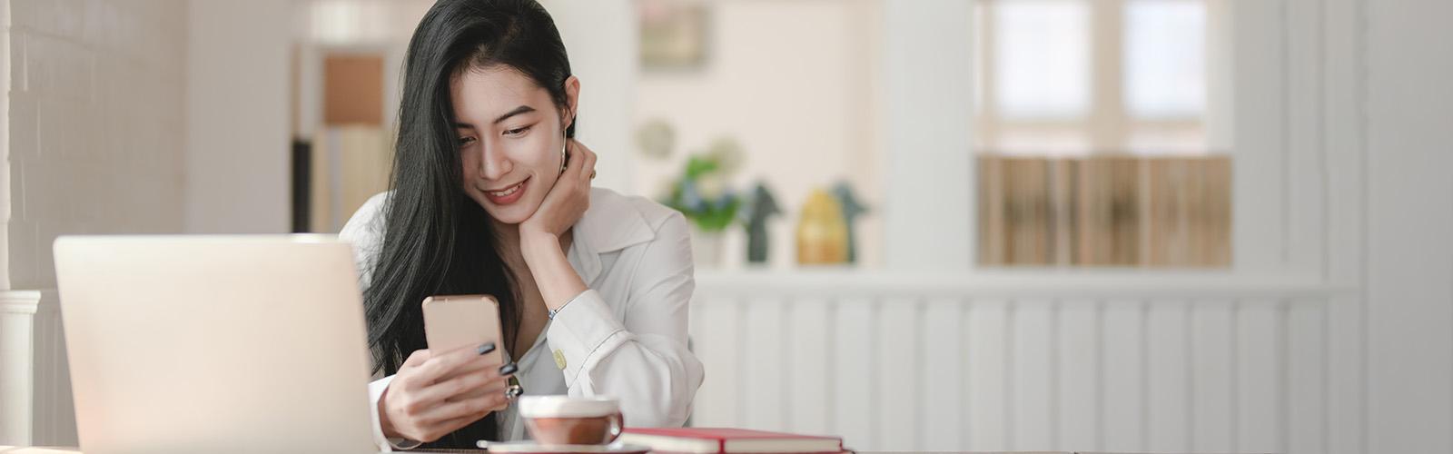 Smiling young woman with open computer