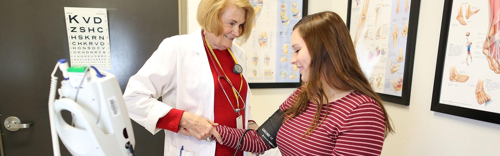 Health Services nurse checking student's blood pressure